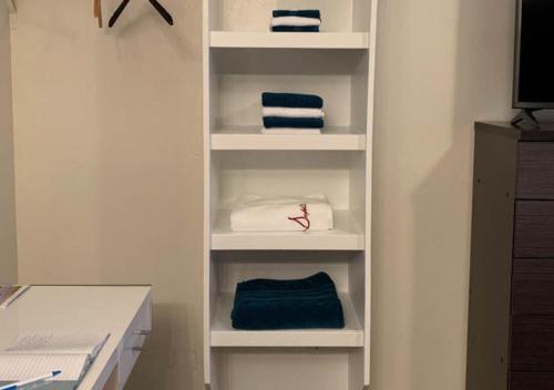 a white book shelf with towels on it at The Wing at Kingston East in Rexburg