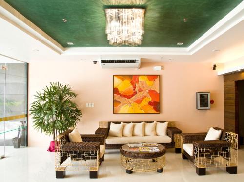 a living room with a couch and chairs at Allure Hotel & Suites in Cebu City