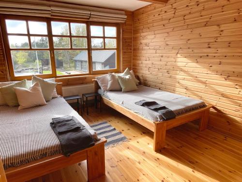 a room with two beds in a log cabin at Āķagals in Pāvilosta