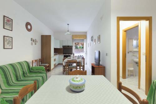 a kitchen and living room with a table and a couch at Appartamento Baiabella by BarbarHouse in Rivabella