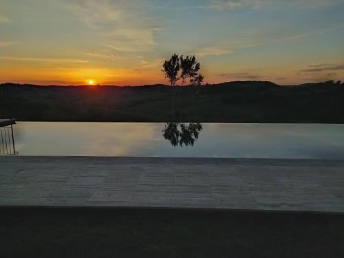 a sunset view of a beach with a body of water at La Pievina in Montepulciano