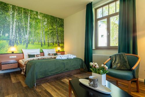 um quarto de hotel com uma cama e uma cadeira em Hotel Villa Halliger em Göhren