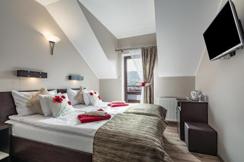 a bedroom with a large bed and a tv at Pieninski Mak. in Szczawnica