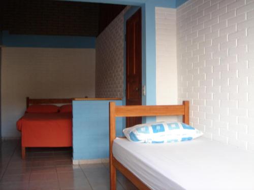 a bedroom with a bed with a pillow on it at Casa Blanka 2010 - Eco Surf Guest House in Itacaré
