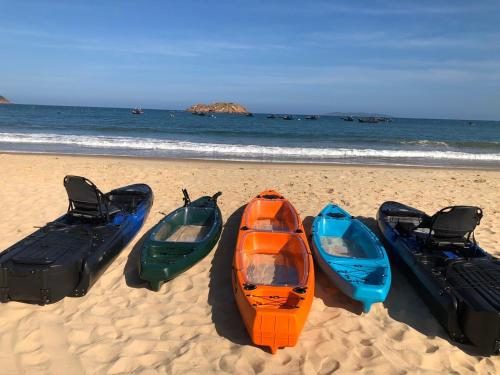 a group of four boats on the beach at Seaside Boutique Resort Quy Nhon in Quy Nhon