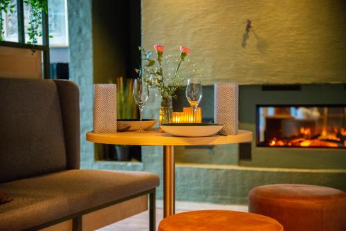 una mesa con 2 copas de vino y una chimenea en Hotell Jæren en Bryne