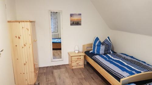a bedroom with a bed and a night stand and a window at Jäger`s Ferienwohnung an der Ostsee in Weitendorf