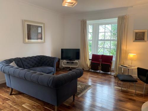 a living room with a couch and a television at Apartment 3 The Grove in Durham