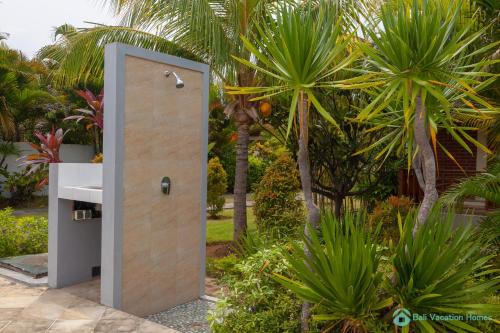 an open door in a garden with palm trees at Villa Lumba Lumba - When perfection isn't enough! in Bubunan
