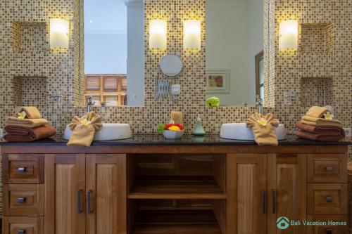 a bathroom with two sinks and a large mirror at Villa Lumba Lumba - When perfection isn't enough! in Bubunan