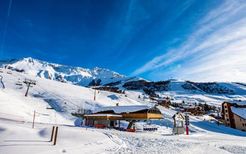 un lodge de esquí en una montaña nevada con montañas cubiertas de nieve en Parc Madeleine - APARTMENTS en Saint-François-Longchamp