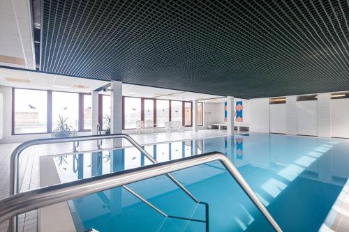 uma piscina com água azul num edifício em Terrassenpark Apartments (Premium Rooms) em Sasbachwalden