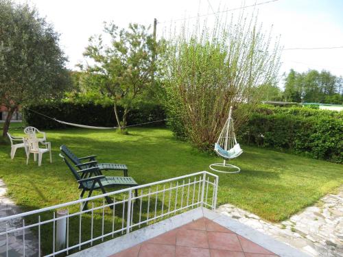 a yard with two benches and a swing at La Mimosa Chic in Pietrasanta