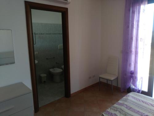 Schlafzimmer mit einer Glastür, die zu einem Bad führt in der Unterkunft Orchidea in Sant'Isidoro