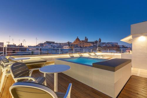 einen Balkon mit einem Pool sowie Tischen und Stühlen in der Unterkunft Palazzo Mascetti Executive Rooms in Ostuni