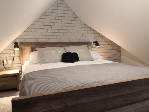 a bedroom with a large bed with a brick wall at Miło Cię widzieć in Łeba