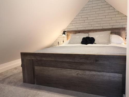 a bedroom with a large bed with a wooden headboard at Miło Cię widzieć in Łeba
