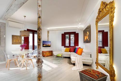 a living room with a table and a mirror at Art Chapiz Apartments in Granada