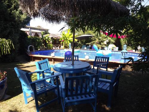 une table bleue et des chaises en face d'une piscine dans l'établissement Chambres d'hotes La Maison Bleue, à Souvans
