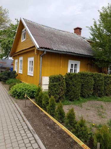 a yellow house with a sidewalk in front of it at "MARKIZAS" Karaimu 25 in Trakai