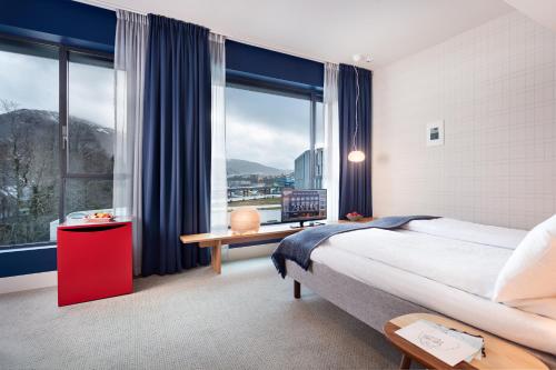 a hotel room with a large bed and a large window at Zander K Hotel in Bergen