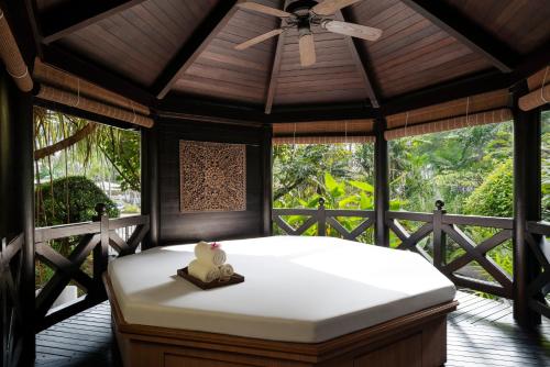 a bed in a room with a ceiling fan at Shangri-La Rasa Sentosa, Singapore in Singapore