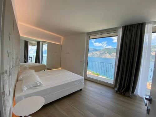 a bedroom with a bed and a large window at My Lake Apartments in Malcesine