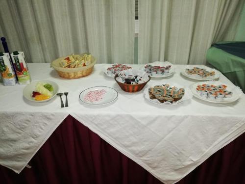 a table with plates of desserts and bowls of food at Hotel Sagittario in San Sperate