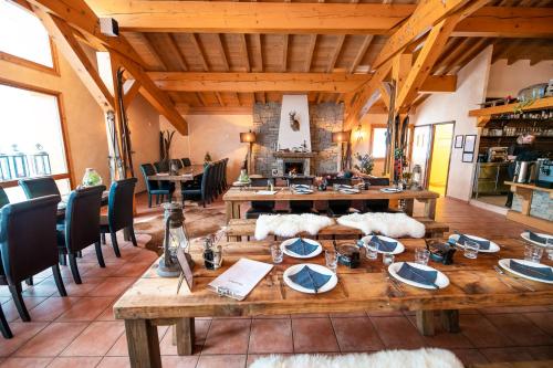 Cette grande chambre dispose d'une table et de chaises en bois. dans l'établissement Parc Madeleine - CHALETS, à Saint-François-Longchamp