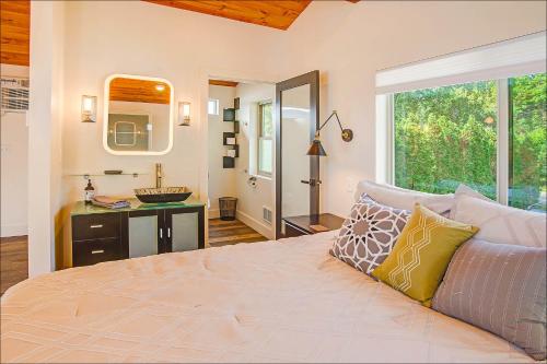a bedroom with a bed with a sink and a mirror at Lake Level Cottages in Oroville