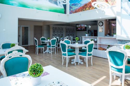 un restaurante con sillas y mesas azules en una habitación en Park Luxury Rooms, en Predeal