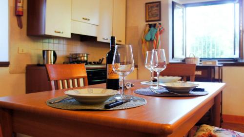 a table with two glasses and a bottle of wine at Agriturismo Casa Agricola Rossi Appartamenti in Casentino in Soci