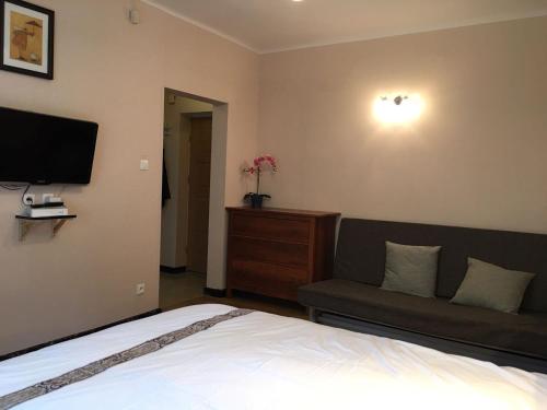 um quarto com uma cama, um sofá e uma televisão em Travel Apartment em Varsóvia