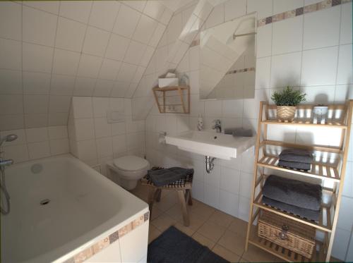 a bathroom with a tub and a sink and a toilet at de lütte Kabuff in Born