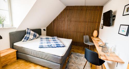 a small bedroom with a bed and a desk at Gasthaus & Hotel Bischoff in Rodgau