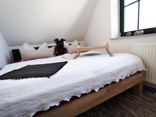 a bed with a teddy bear sitting on top of it at de lütte Kabuff in Born