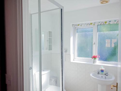 a white bathroom with a shower and a sink at Airport Lounge - 3 Bed - 6 Persons in Manchester
