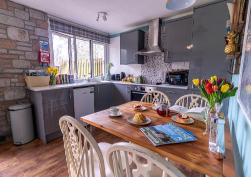 a kitchen with a wooden table and chairs at Ocean Cottage in Uny Lelant