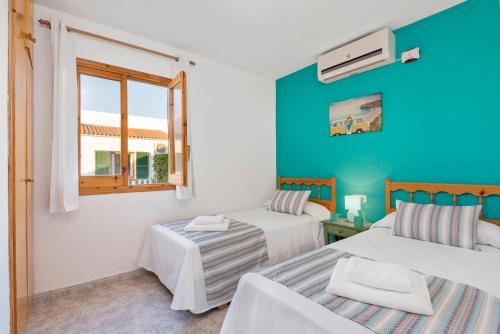 a bedroom with two beds and a window at Villas Pomelo & Papaya in Cala en Blanes