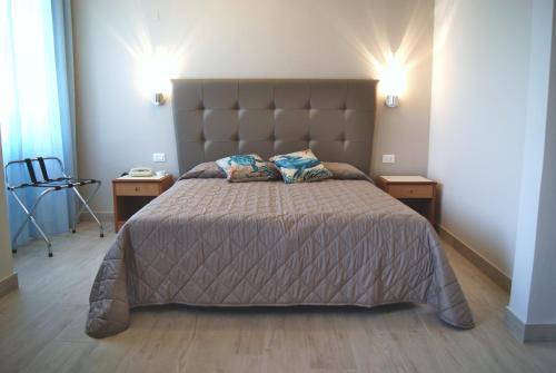 a bedroom with a large bed with two night stands at Hotel Sogno in Viareggio