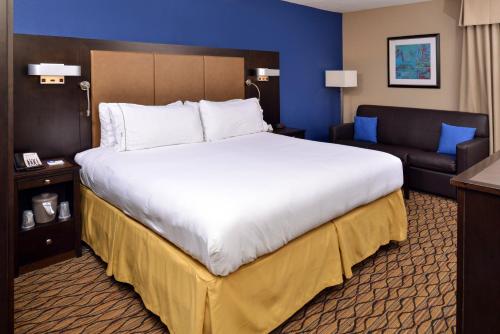 a large bed and a couch in a hotel room at Holiday Inn Express Hunt Valley by IHG in Hunt Valley