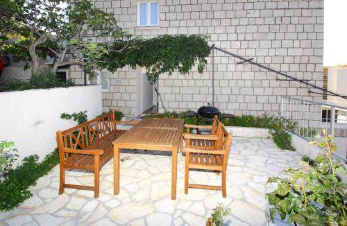 a patio with a wooden table and two chairs at Apartments Dubreta in Cavtat