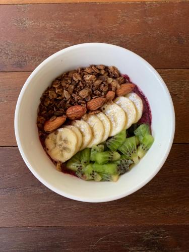 a white bowl of food with bananas and nuts at Namtok Sarika Resotel in Nakhon Nayok