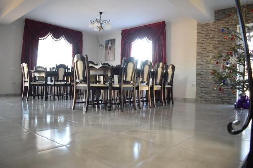 a dining room with a table and chairs and a christmas tree at Casa Dumitru in Ceraşul