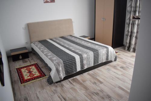 a bed in a room with a wooden floor at Casa Dumitru in Ceraşul