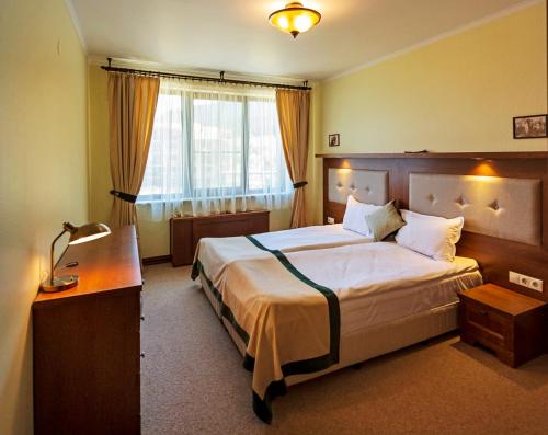 a hotel room with a large bed and a desk at 7 Pools SPA Boutique Hotel in Bansko