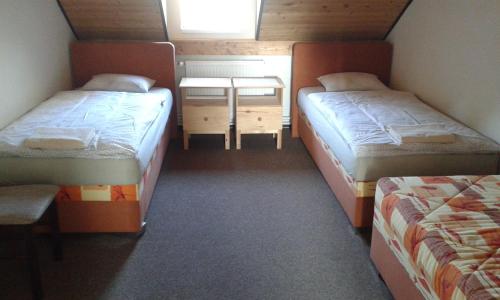 a small room with two beds and a table at Hotel & Restaurant Adolfovský Dvůr in Adolfov