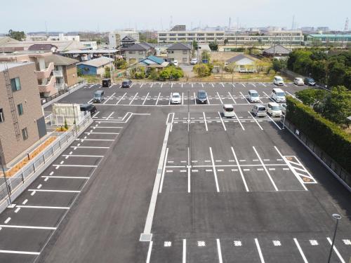 an empty parking lot with cars parked in it at Tabino Hotel Kashima in Kamisu