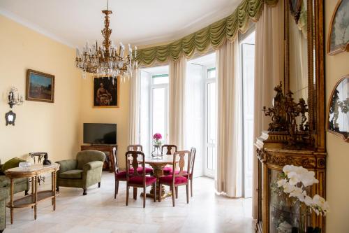a living room with a table and chairs and a chandelier at Casa Bellevue in Naples