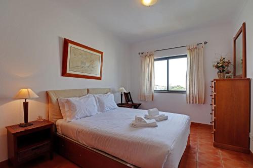 a bedroom with a bed with two towels on it at Pêra Secret Garden 1 and Pool by Homing in Pêra